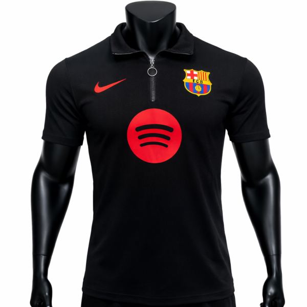 Black polo shirt with a zip collar, displaying a red Nike swoosh on the left chest, a Barcelona crest on the right chest, and a large red Spotify logo centered on the front.