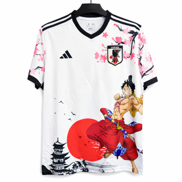 White Japan football jersey with pink cherry blossoms and a large Luffy illustration on the front.