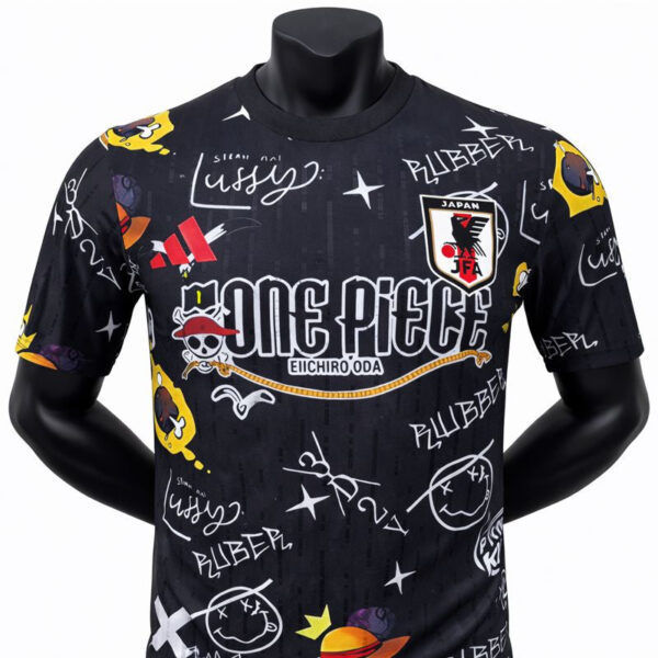 Black T-shirt featuring a 'One Piece' graphic with pirate badges, doodles, and logos across the front and sleeves, bold central text read 'ONE PIECE'.