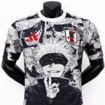 Black-and-white manga-style graphic T-shirt featuring characters and a Japan Football Association patch on the chest
