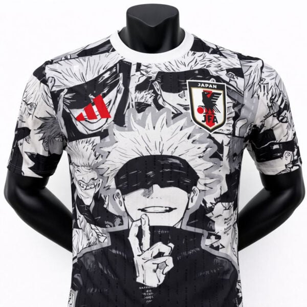 Black-and-white manga-style graphic T-shirt featuring characters and a Japan Football Association patch on the chest
