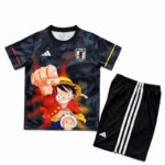 Children's sports outfit: black T-shirt with anime character Monkey D. Luffy graphic and a Japan crest, paired with black shorts featuring white Adidas stripes.