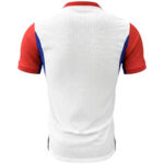 Back view of a white athletic jersey with red sleeves and blue side panels in blue accents.