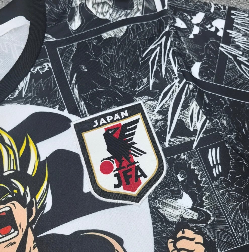 D5ABBC50-E540-488C-A88C-AE9C69526AA9 | UAE SPORT STORE Close-up of a Japan Football Association emblem on a black-and-white manga-themed jersey, with bold panels in the background.