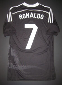 Back of a black soccer jersey with 'RONALDO' and the white number 7; white shoulder stripes visible.",