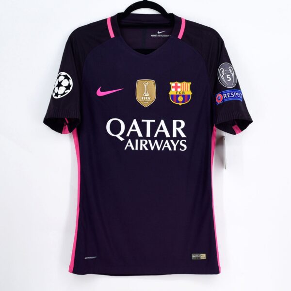 Dark blue FC Barcelona soccer jersey with pink accents on a hanger, featuring Qatar Airways sponsor text, Nike swoosh, Barca crest, and UEFA/Champions League patches on the sleeves.