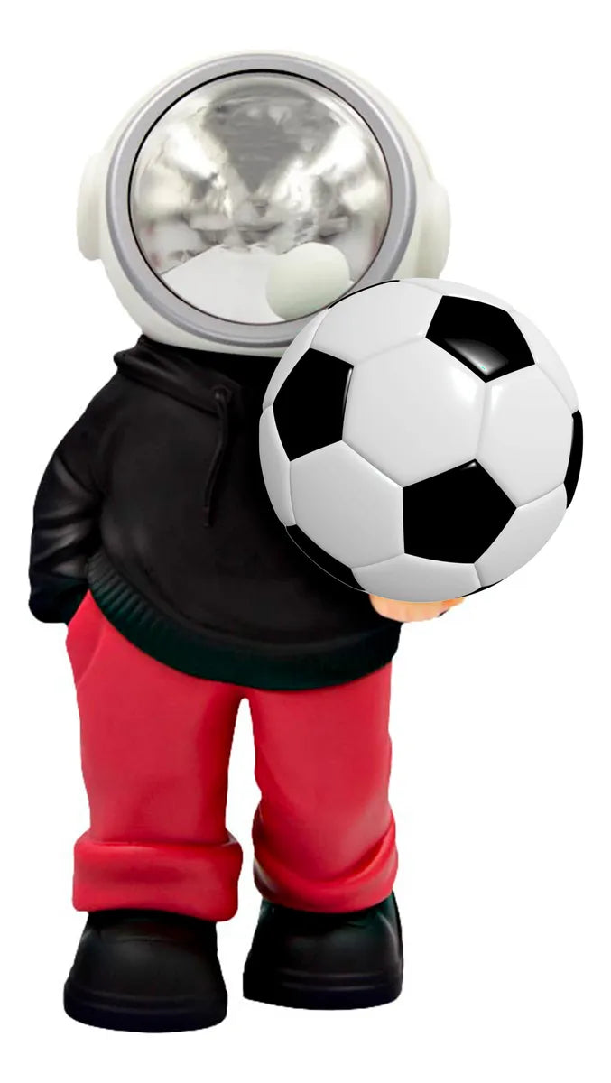 D_NQ_NP_2X_779281-MLM105766185263_012026-F-bocina-lampara-led-inalambrica-astronauta-balon-futbol | UAE SPORT STORE Plastic astronaut figurine with a shiny round helmet, holding a soccer ball against a white background, wearing red pants and black shoes.