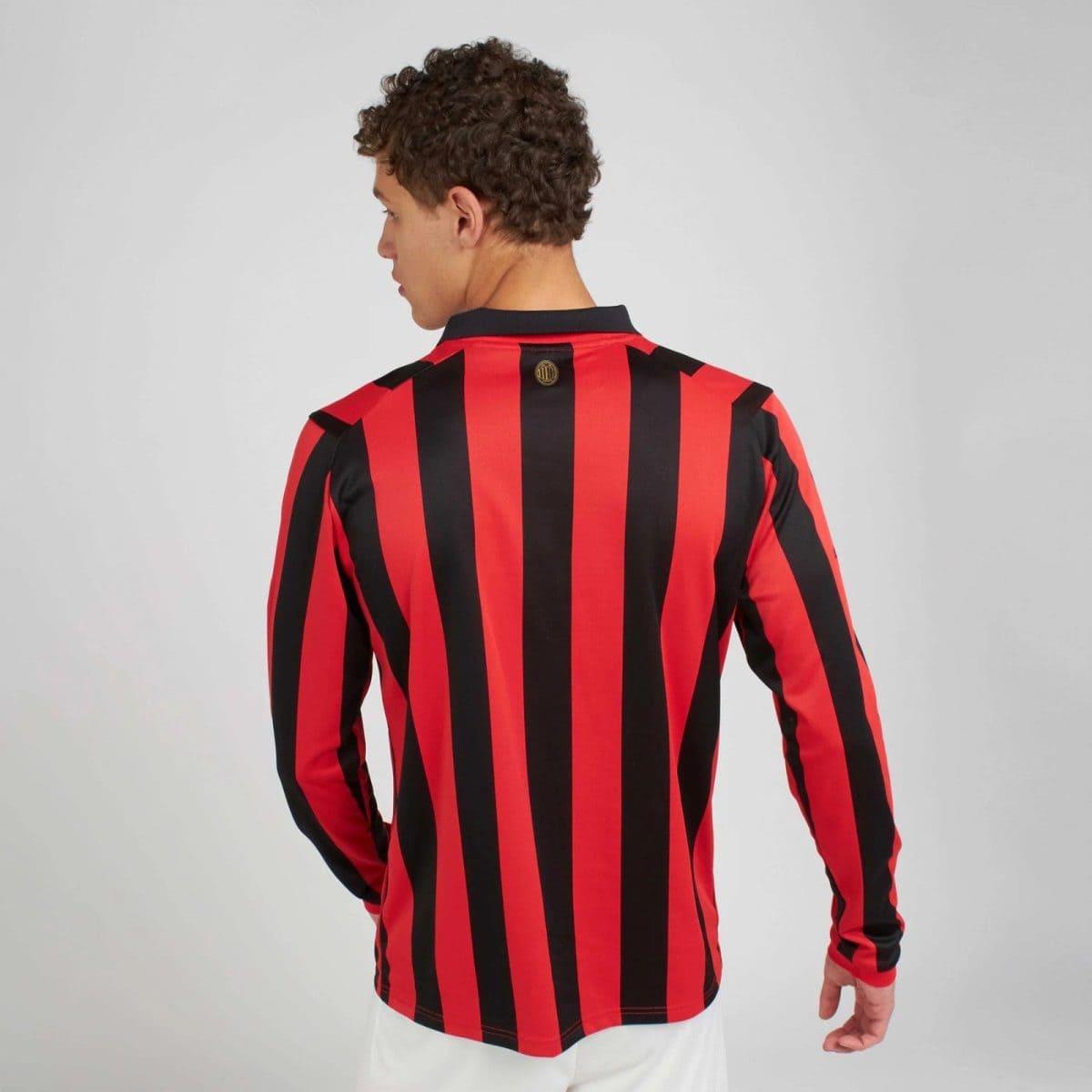 Back view of a person wearing a red and black vertical striped jersey with a black collar (soccer/football jersey).