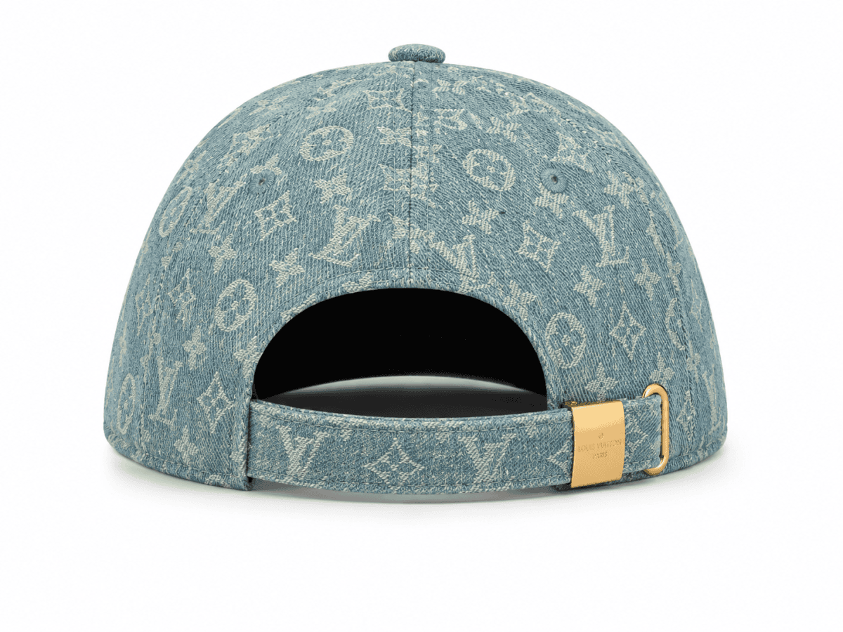 Back view of a blue denim Louis Vuitton cap with monogram pattern and a gold buckle strap closure