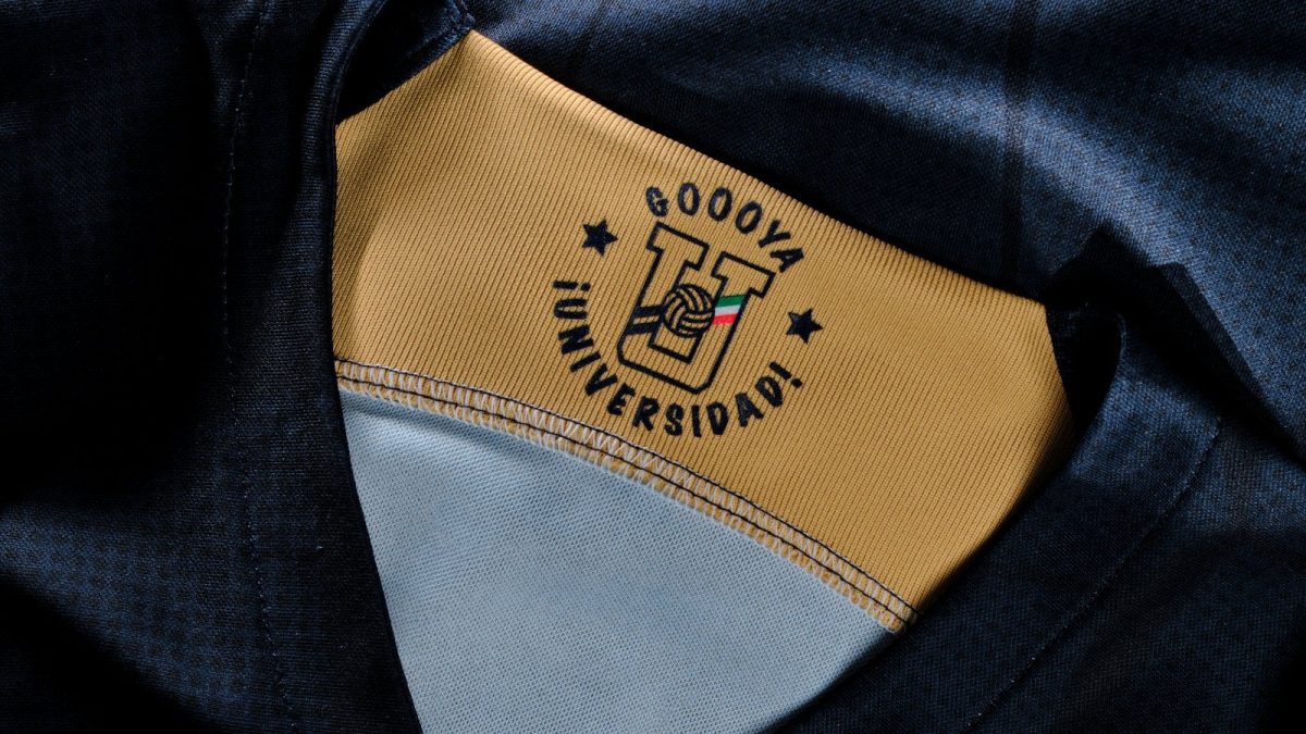 Close-up of a tan fabric patch with a university emblem and a small Italian flag, sewn inside a dark jacket.
