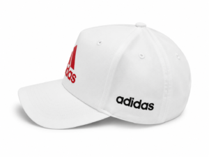 White Adidas baseball cap with a red logo on the front and black Adidas text on the side, curved brim facing left.