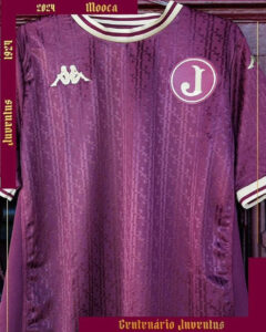 Purple youth soccer jersey with Kappa logo on the left chest and a circular badge with a white 'J' on the right chest.