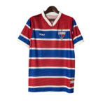 Red and blue striped Fortaleza football jersey with white trim on sleeves and collar, featuring the club crest on the chest and a Volt logo.