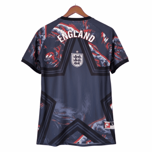 Back view of an England national football jersey on a wooden hanger: dark navy with red/white abstract patterns, large 'ENGLAND' text across the shoulders, and a crest near the upper back.