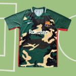 Camouflage FC Barcelona jersey with Rakuten sponsor and club crest on a green background.