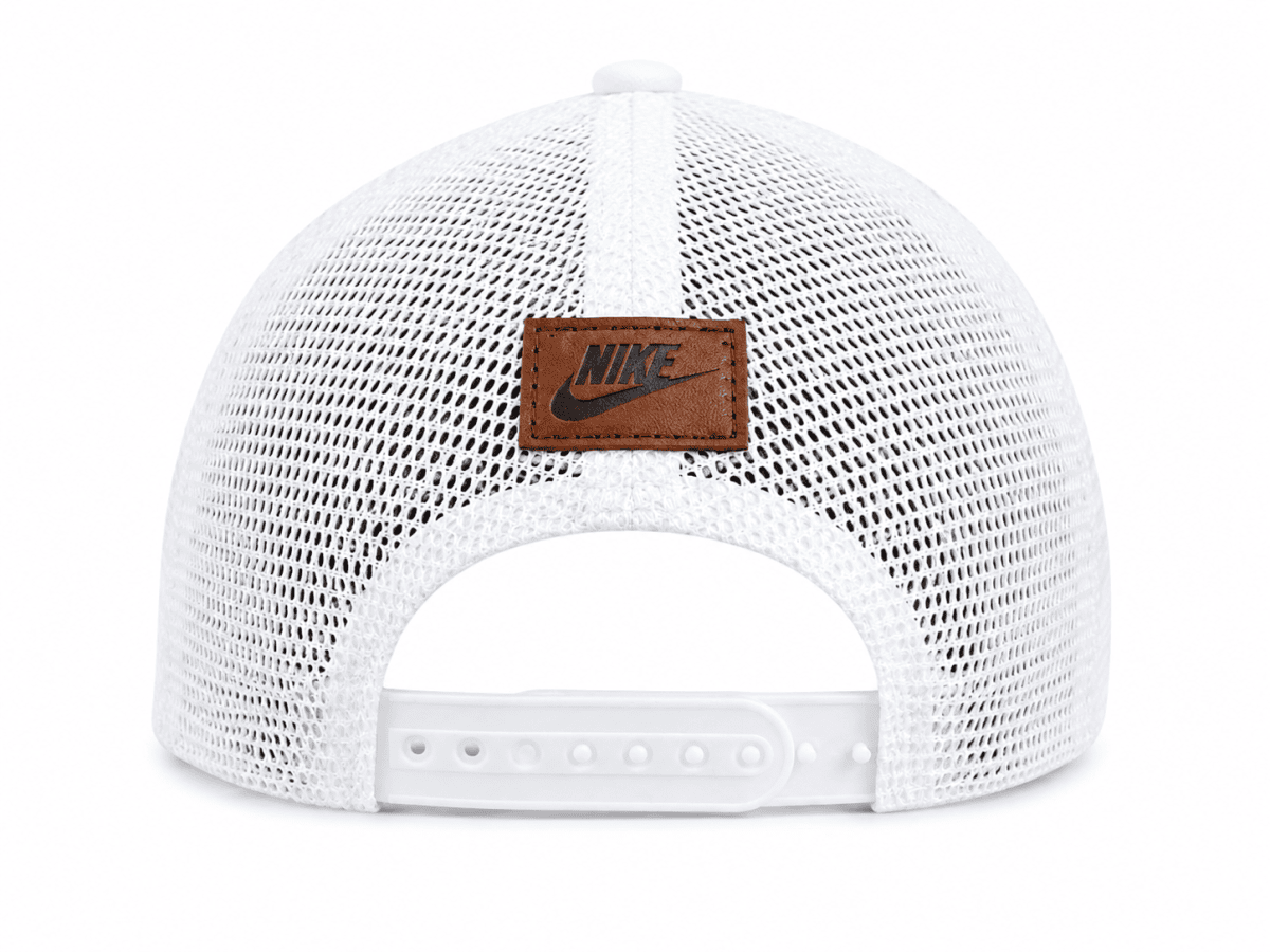 Back view of a white Nike mesh trucker cap with an adjustable strap and brown leather logo patch