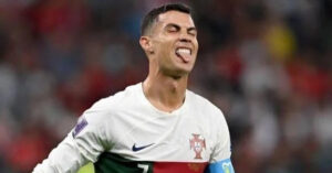 Portuguese soccer star Cristiano Ronaldo sticking out his tongue in celebration on the field, wearing Portugal jersey with the number 7 and captain’s armband.