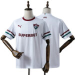 White soccer jersey on display with maroon sponsor 'SUPERBET', crest, and green-red sleeve stripes on the cuffs.