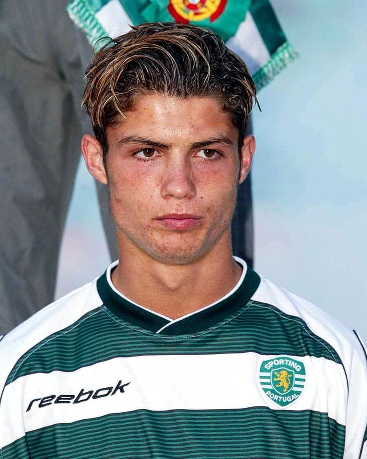 Fo3JbIfakAAjszU_d9e7157a-033e-40d1-b6a8-69333063aaa7 | UAE SPORT STORE Young man in a green-and-white striped Sporting Portugal jersey, looking serious and facing forward