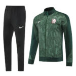 Black Nike track pants with white swoosh paired with a green patterned full-zip training jacket featuring a crest and geometric text design for sportswear