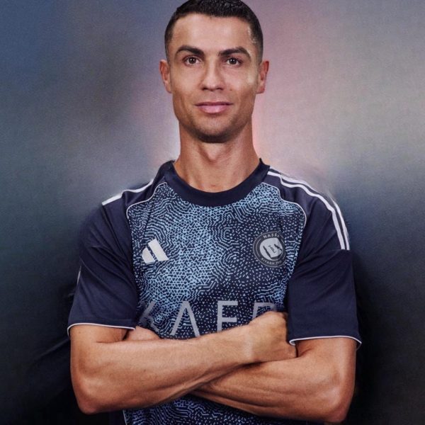 Athlete with arms crossed, wearing a dark blue patterned jersey with a badge on the chest.