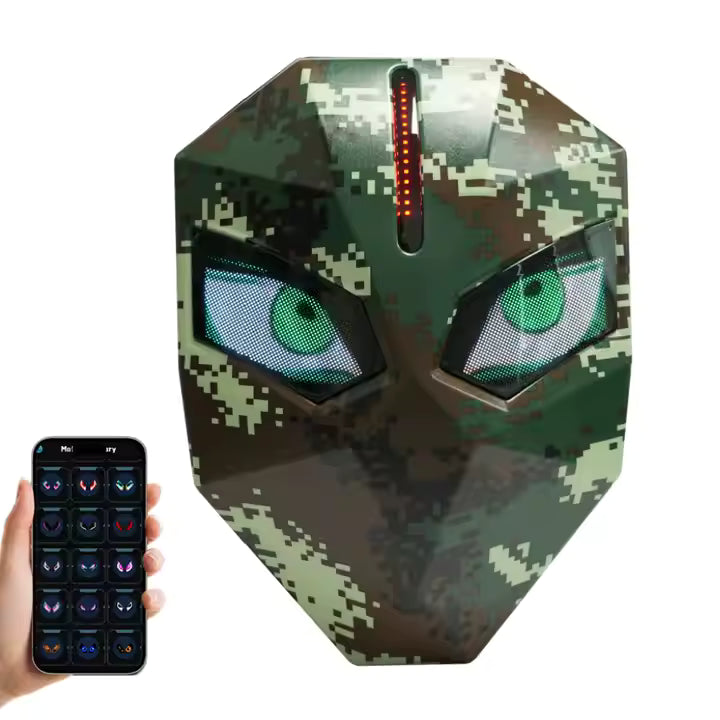 H18c56ef46f974501a886d8b67ca71b9aK Camouflage digital mask with glowing green eyes and a vertical LED strip on the forehead, controlled by a smartphone app shown to the left.