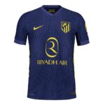 Navy blue Atlético Madrid jersey with yellow sponsor logo 'Riyadh Air' and crest, striped pattern and yellow Nike swoosh.