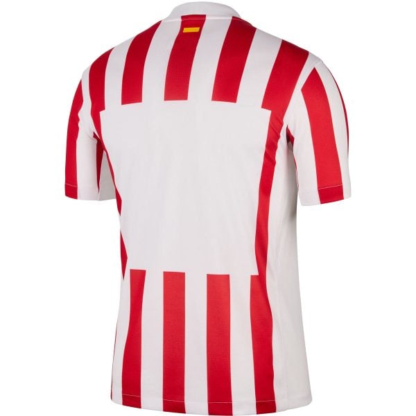 Back view of a white sports jersey with bold red vertical stripes and a small yellow tag at the collar, typical of a football shirt.