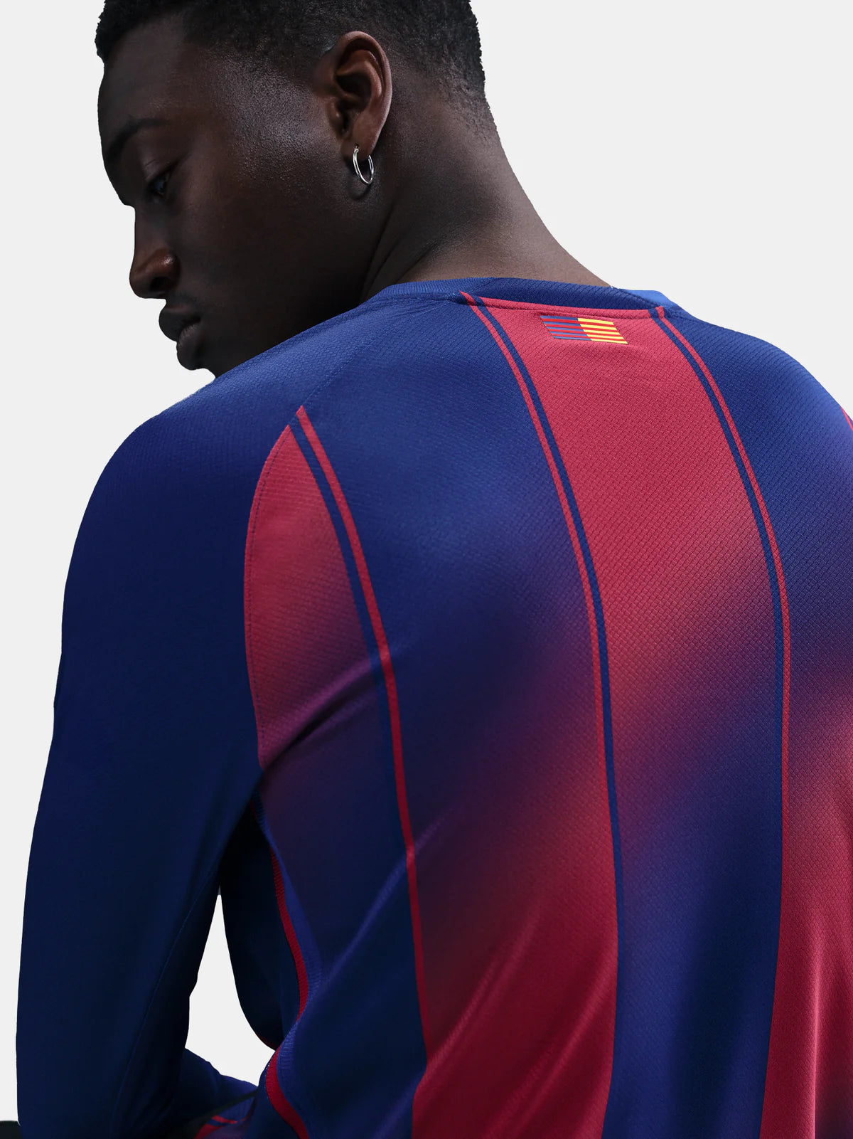 HJ4611-456-PHSYMG02 | UAE SPORT STORE Back view of a person wearing a blue and red striped athletic jersey with a small flag patch near the neck.