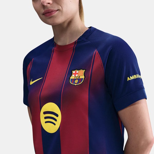 Close-up of a person wearing a FC Barcelona football jersey with blue and red vertical stripes, crest on the left chest, and a yellow Nike swoosh.