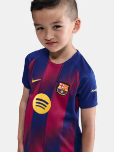 Young boy wearing a FC Barcelona soccer jersey in blue and red, facing the camera with a slight smile.