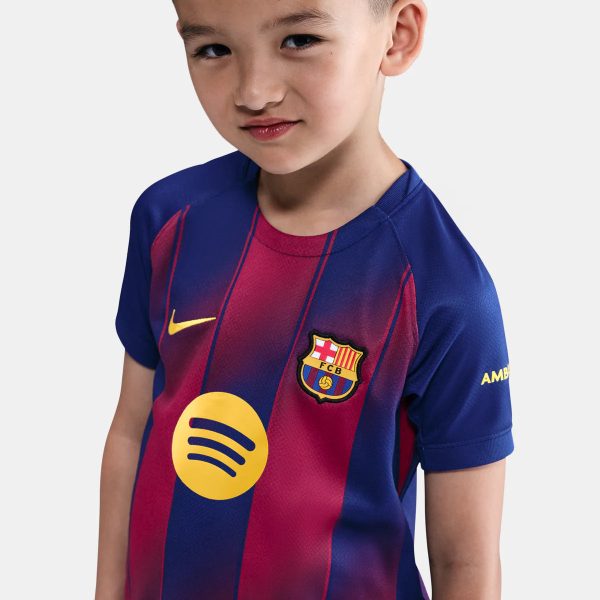 Young boy wearing a FC Barcelona soccer jersey in blue and red, facing the camera with a slight smile.