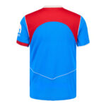 Back view of a blue and red athletic jersey with white piping and curved blue panel across the upper back.