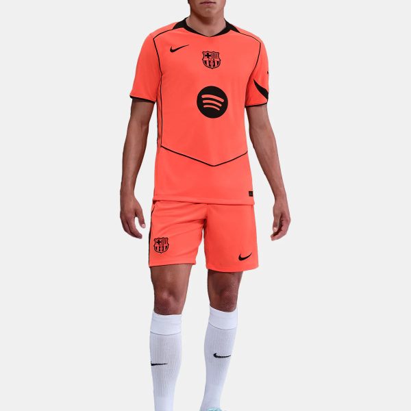 Coral FC Barcelona football jersey and shorts set with Nike logo and Spotify sponsor, worn with white socks and light-blue boots.