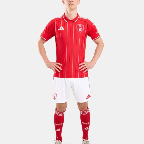 Man in red striped soccer jersey and white shorts posing with hands on hips, full-body shot.