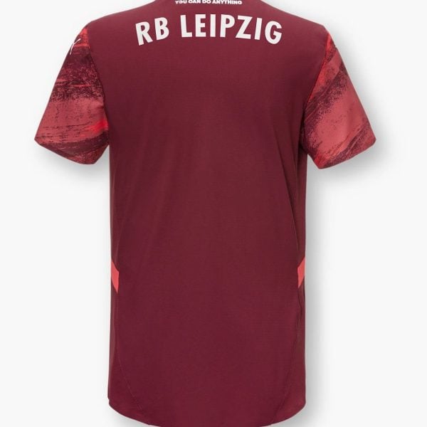 Back view of a maroon RB Leipzig soccer jersey; white 'RB LEIPZIG' text across the upper back, orange collar, red patterned sleeves.
