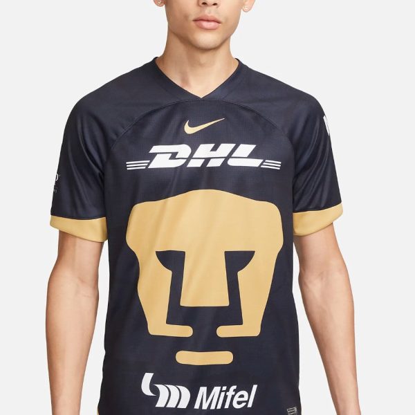 Young man in a navy DHL-sponsored sports jersey with a large beige graphic on the front and gold Nike swoosh.
