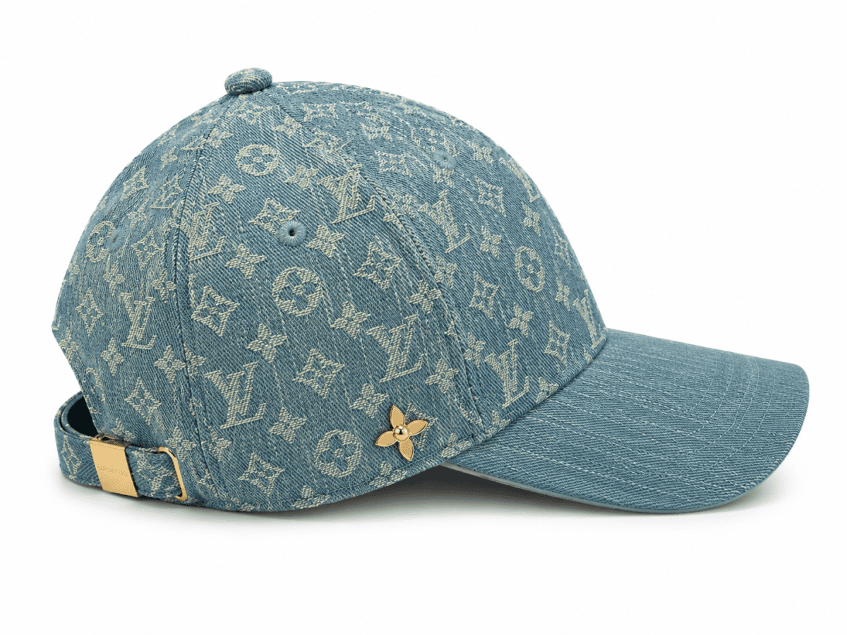 Denim cap with Louis Vuitton monogram pattern, gold back strap buckle, and small gold flower pin edge detail.