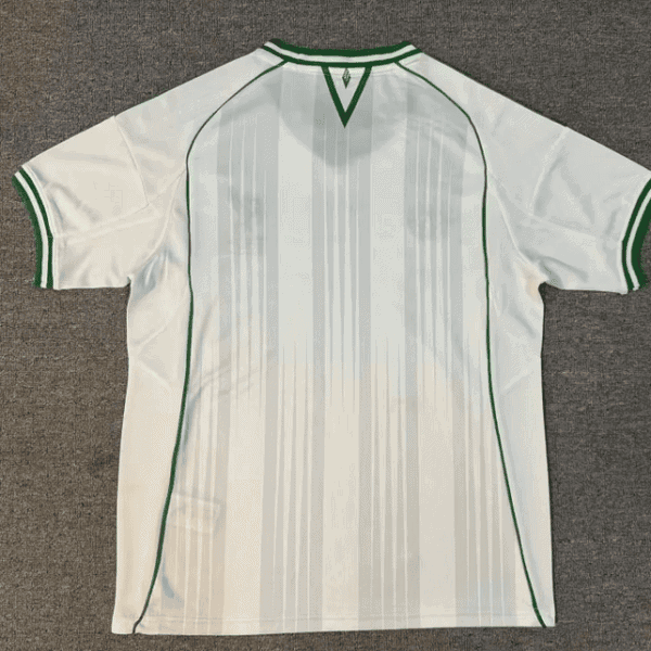 White soccer jersey viewed from the back with green trim and vertical pale stripes, short sleeves, and a green V-shaped neck trim on a gray background