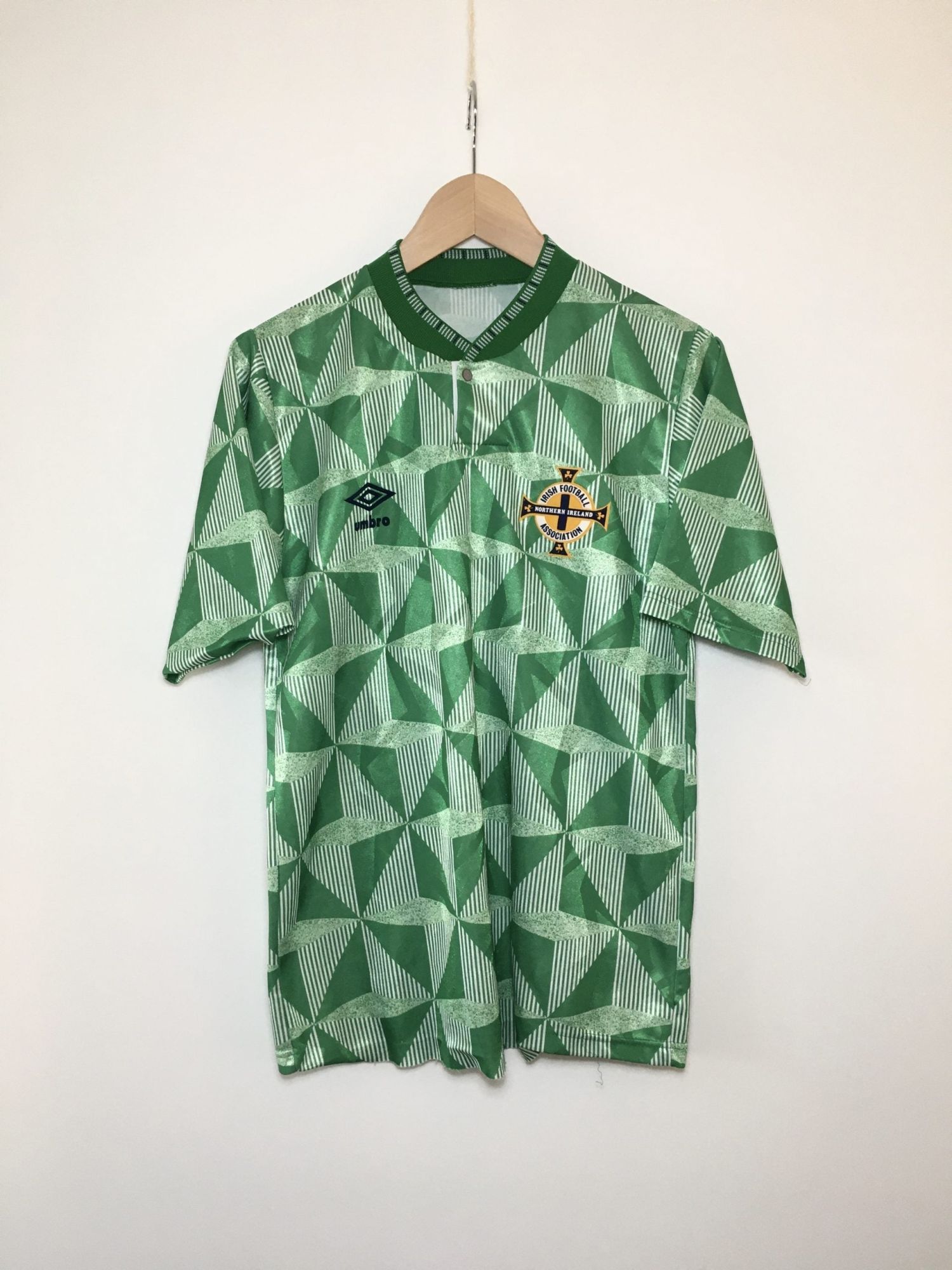 IMG_6512-scaled_0d9a8a78-b80e-467d-b0e9-72b523dcd294 | UAE SPORT STORE Green football jersey with a white geometric triangle pattern, Umbro logo, and Irish Football Association crest on the chest.