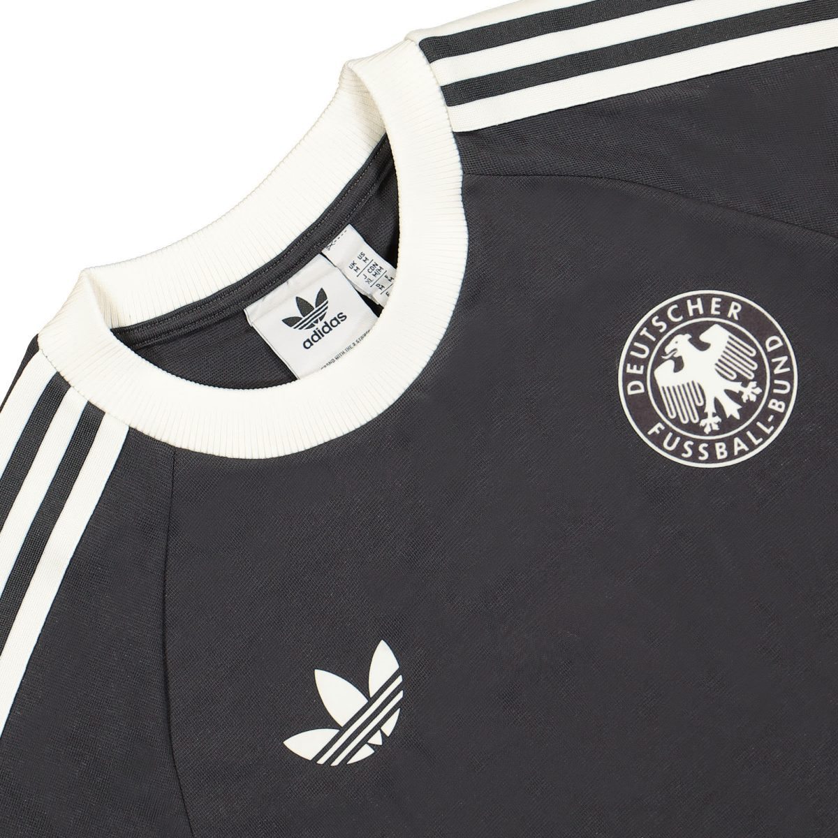 Close-up of a black football jersey with white stripes and the DEUTSCHER FUSSBALL-BUND emblem on the chest.