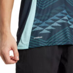 Close-up of a teal and navy athletic shirt with a geometric pattern and the AEROREADY logo.