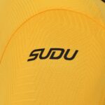 Close-up of yellow knit fabric with a black 'ODU' logo.