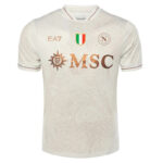 Front view of a white soccer jersey with copper-toned MSC logo across the chest and a small Italian flag shield above it.