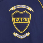 JJ4286_03 | UAE SPORT STORE Embroidered crest on dark blue fabric: shield with CABJ in yellow, flanked by '120 Aniversario' and '1905-2025' banners.