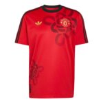 Red Manchester United Adidas football jersey with a dark red floral pattern and crest on the chest.