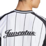 Back of a person wearing a white jersey with black vertical pinstripes and the Juventus logo across the back