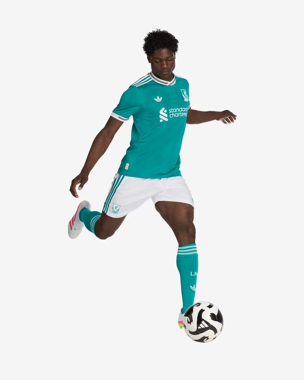 JV6427_5_APPAREL_OnModel_WalkingView_custom_1-lowres | UAE SPORT STORE Soccer player in teal away kit with white shorts kicking a soccer ball.