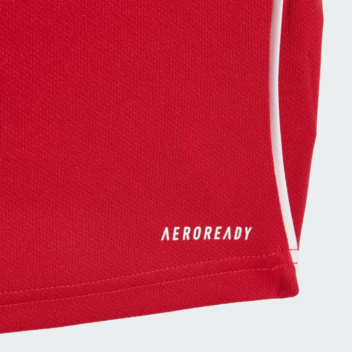 Close-up of red knit fabric with a thin white seam running along the edge.