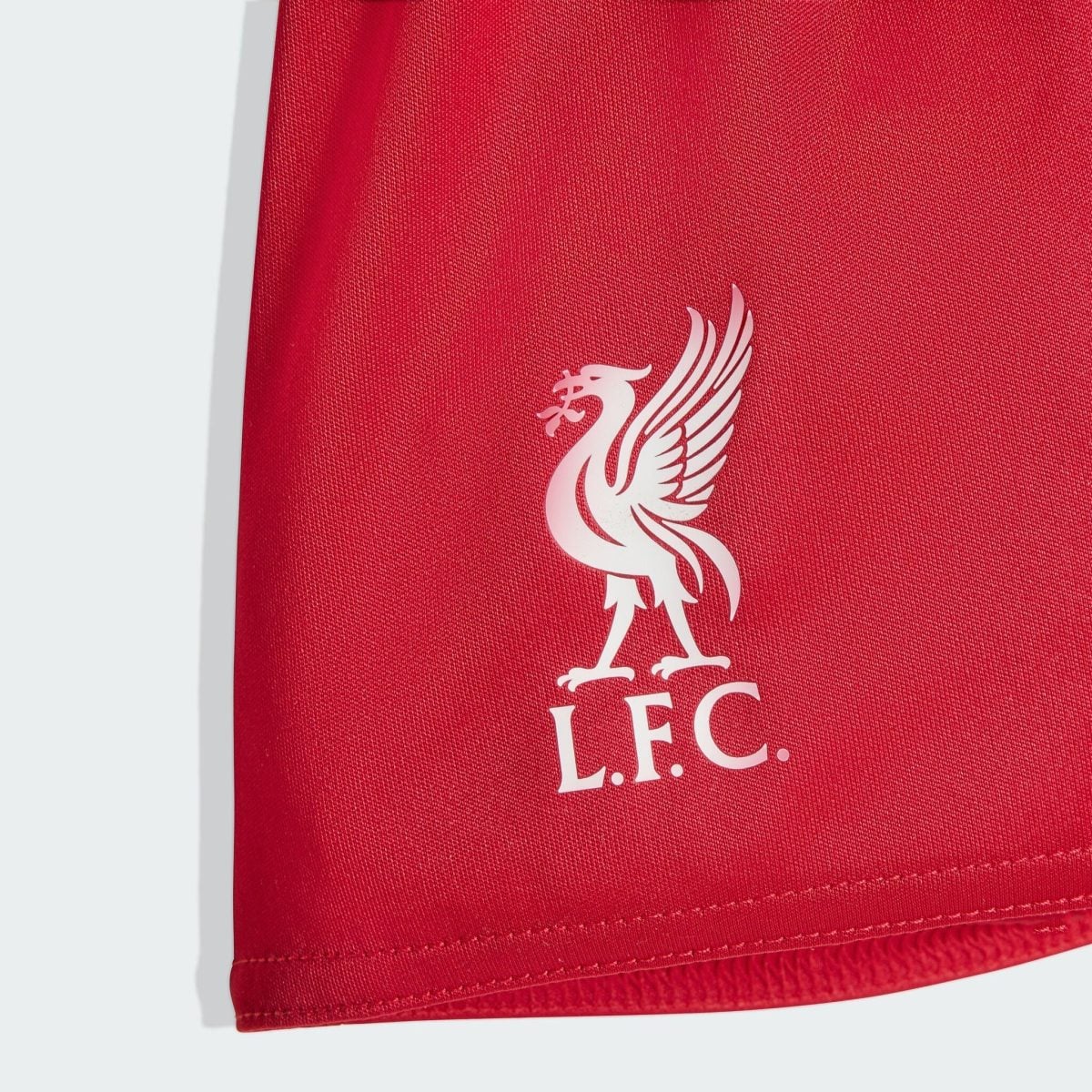 Close-up of a red fabric surface featuring a white Liverpool FC crest partially visible.